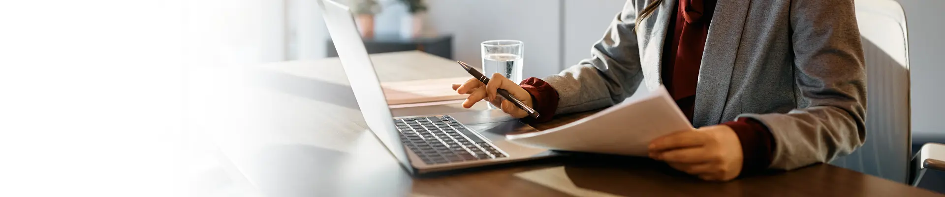 Close up of person on laptop and holding documents