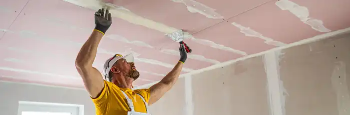 Tradesman working on ceiling of house