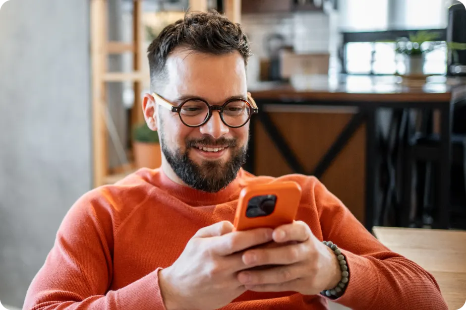 Man smiling while look at his phone at home
