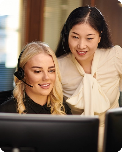 female intern working with a female employee discussing something on a computer