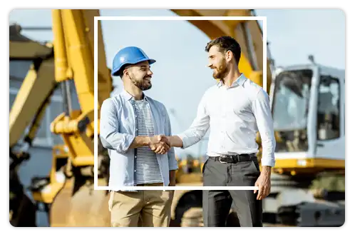 Business man and construction worker shaking hands at jobsite