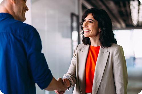 Woman smiling while shaking a partners hand