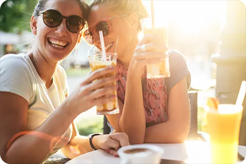 Two friends smiling while having a drink