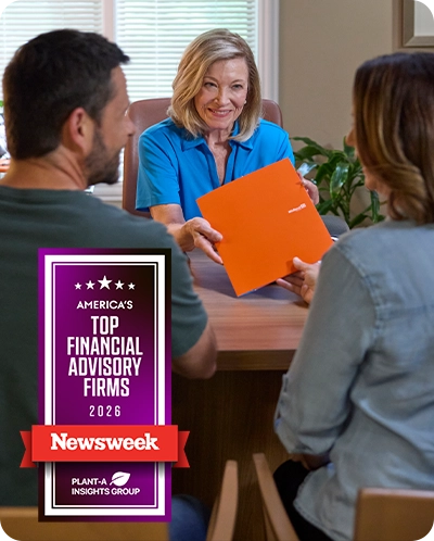 Couple talking with wealth advisor in office with Newsweek award emblem overlaid