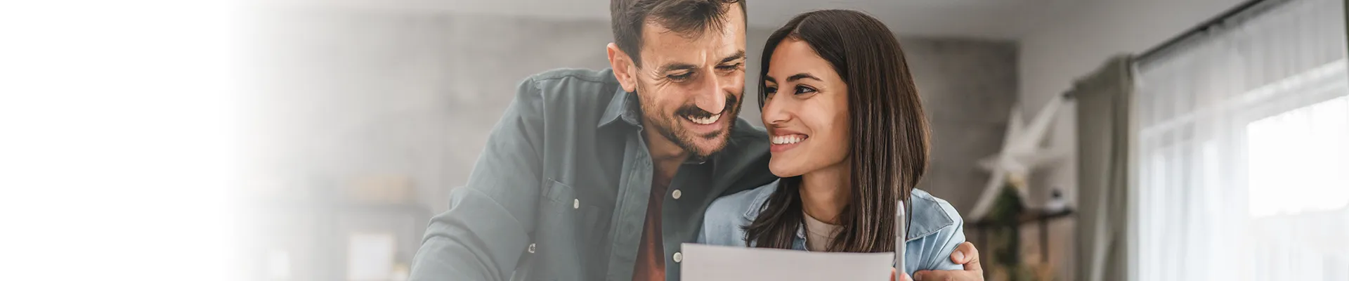 Couple smiling as they look over papers