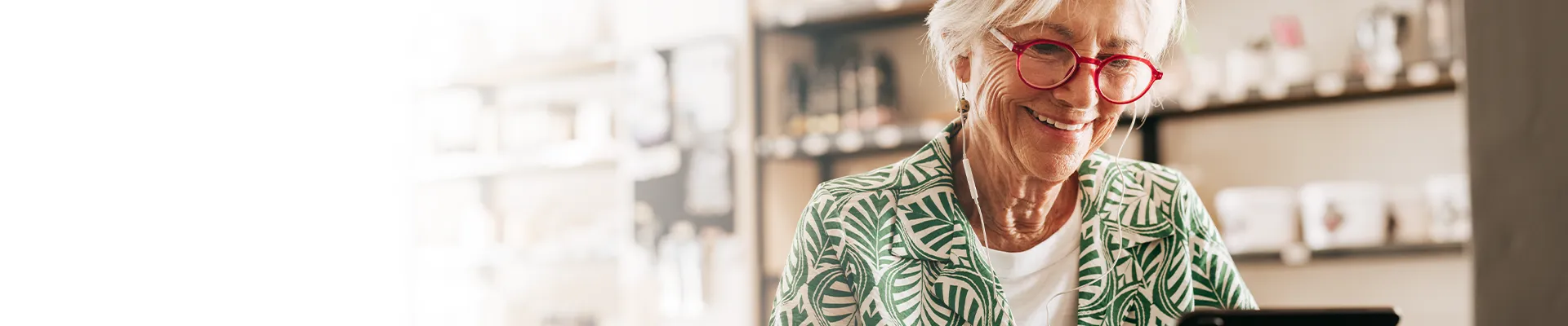 Older woman smiling while looking at tablet