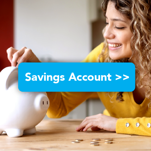 Woman smiling while putting a coin into her piggy bank