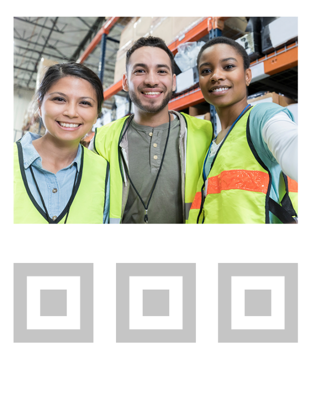 coworkers in yellow safety vests smiling and standing in warehouse