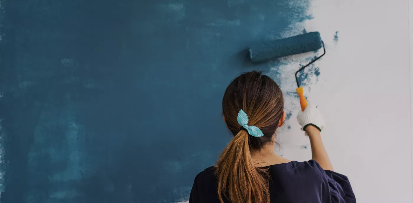 woman painting wall blue