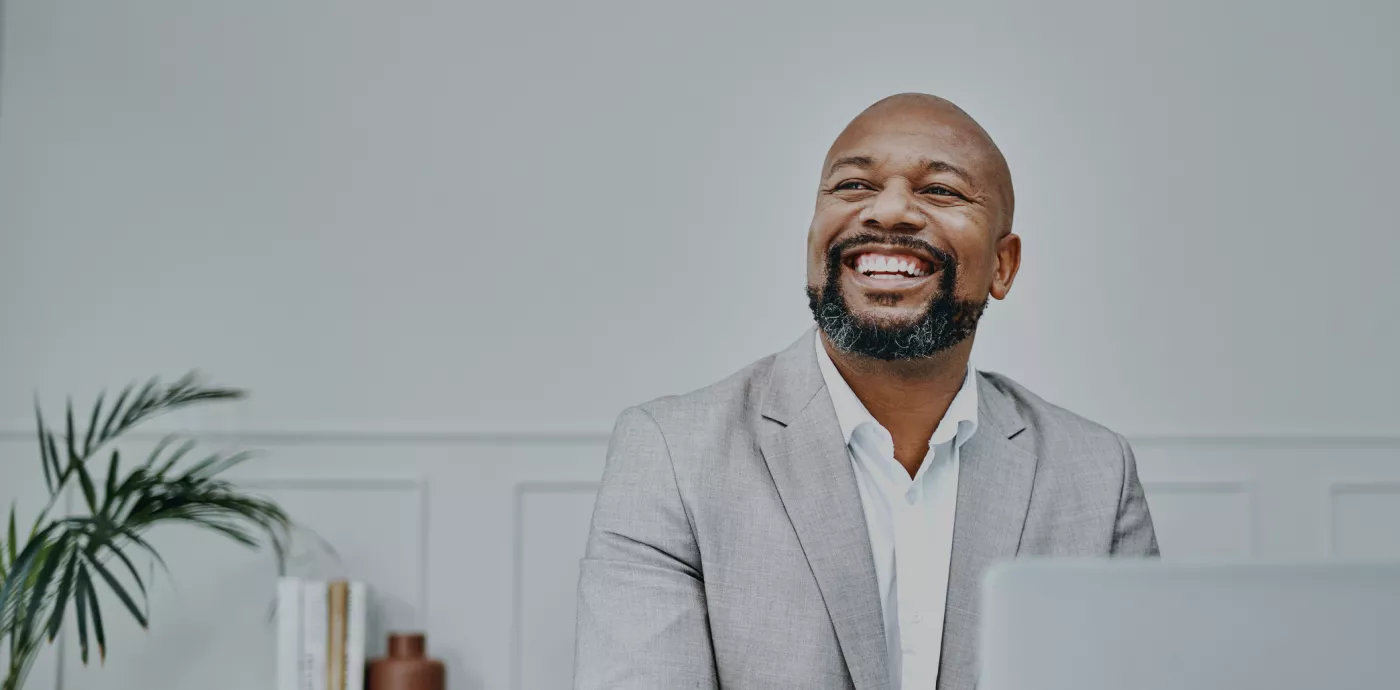 black business man smiling as he looks away from camera