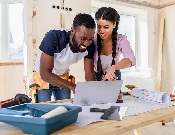 Couple looking at laptop while planning home improvements