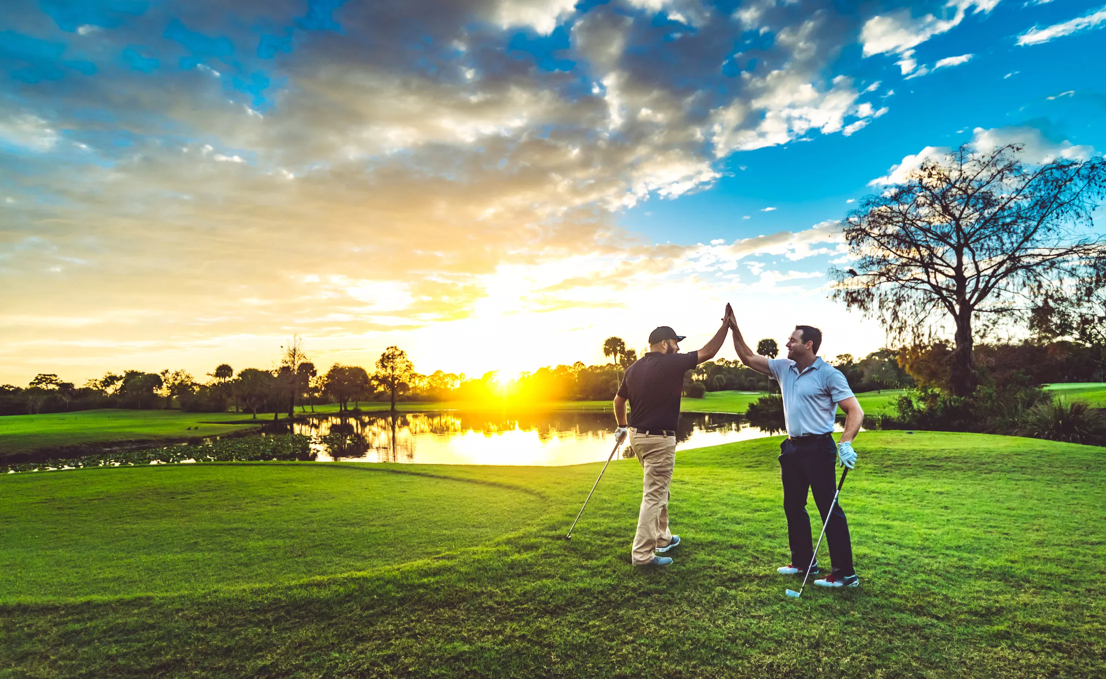 two golfers high fiving on the course