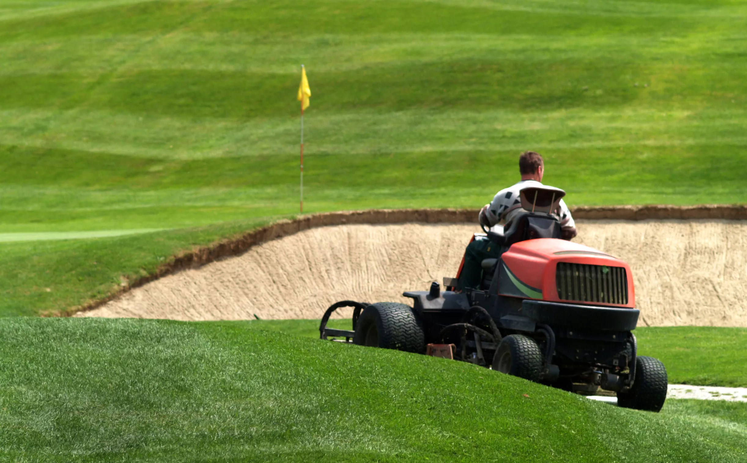 worker mowing golf course