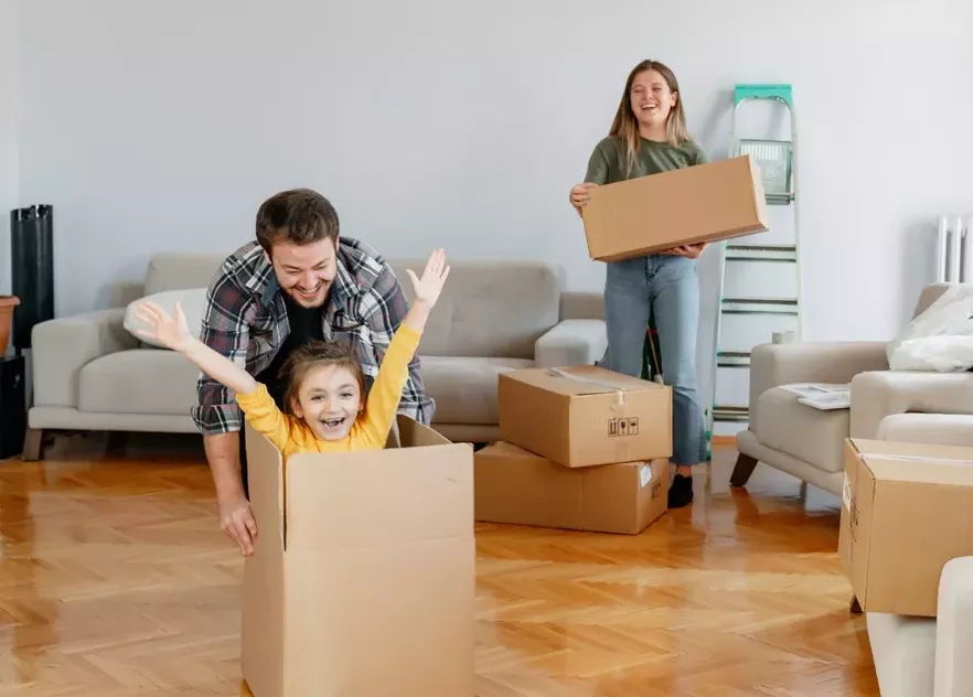 family having fun while moving in a new home