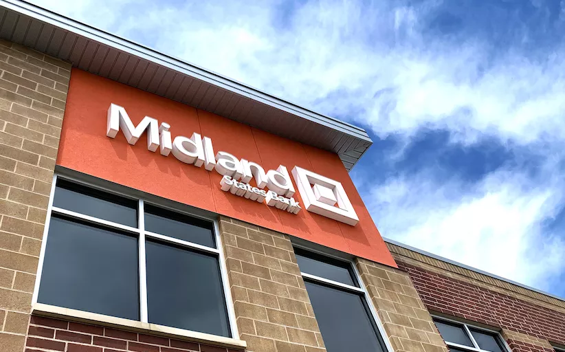 orange midland sign against a blue sky
