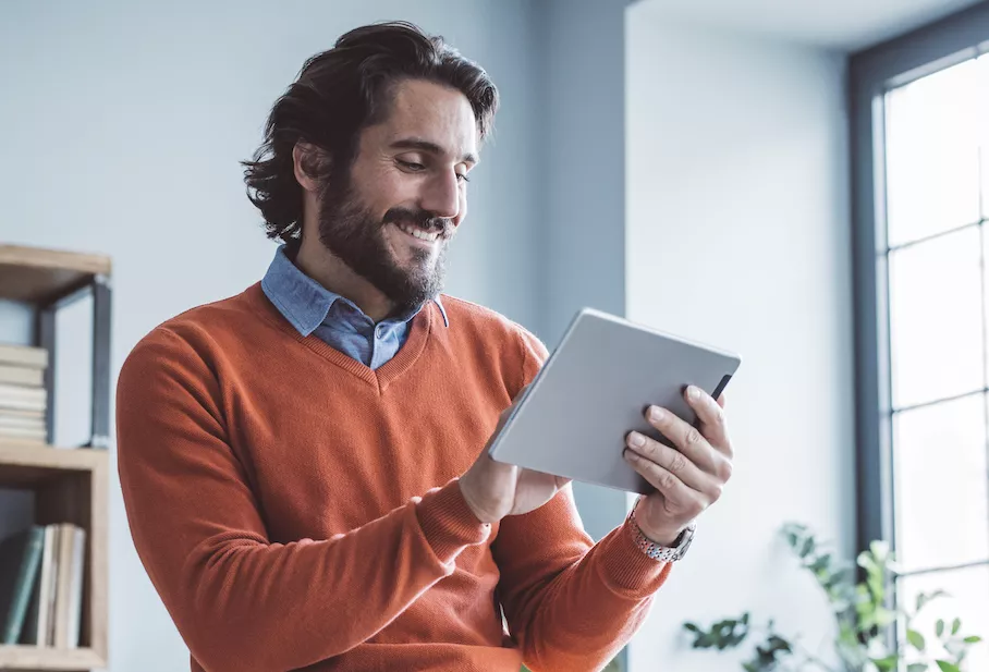 man looking at tablet and smiling
