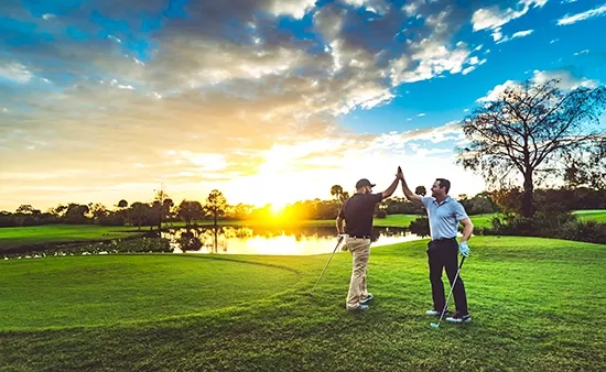two golfers high fiving on the course