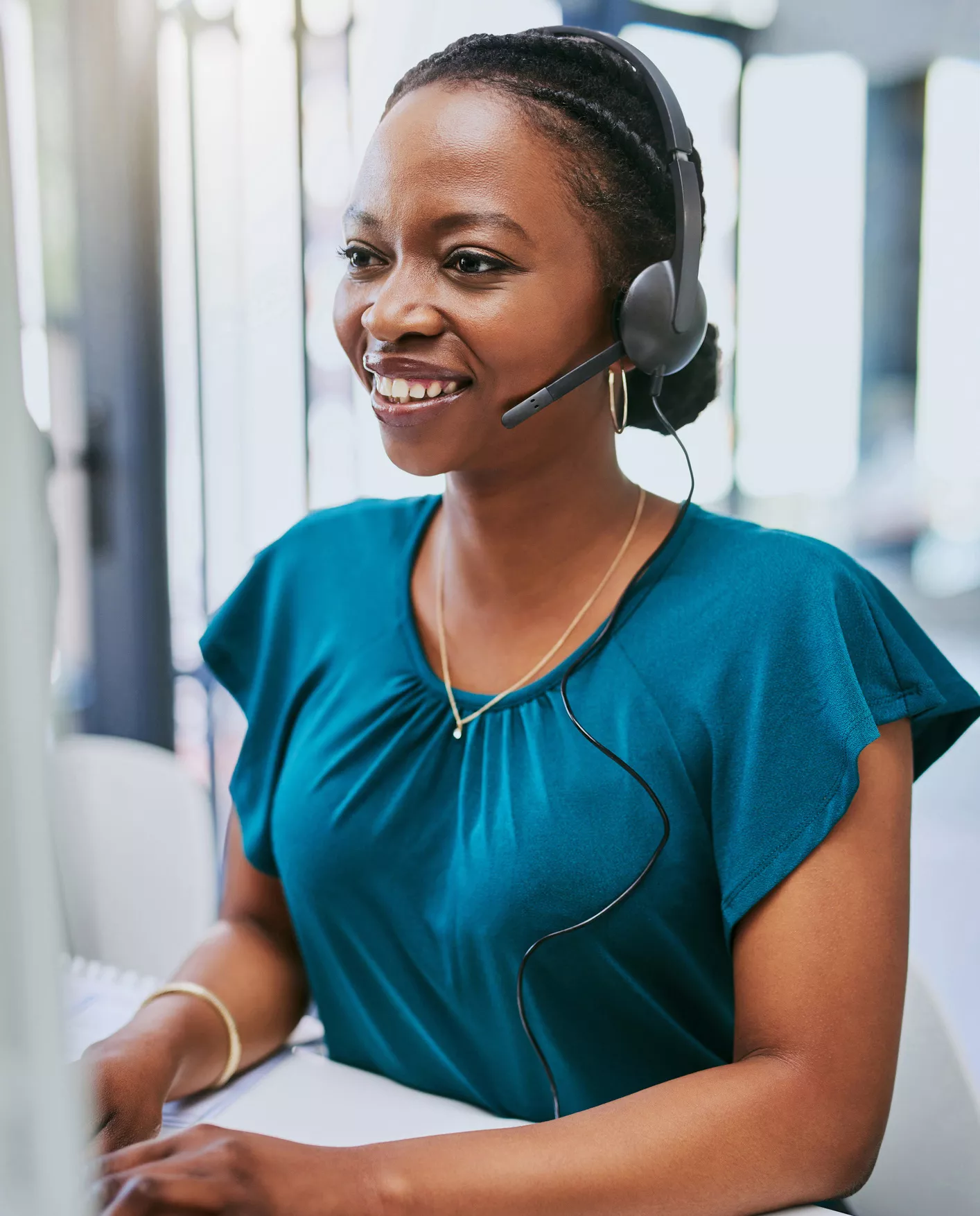 woman smiling as she talks with customer over her headset